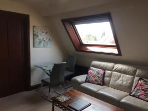 a living room with a couch and a table and a window at Stylish Apartment in Stone-Built Former Rectory in Penrith