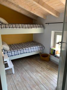 a bedroom with bunk beds in a room with a window at CASA DELLA LUCE private pool in Bagnone