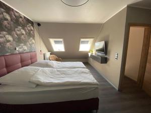 1 dormitorio con 1 cama grande y cabecero rosa en Encore Seaside, en Büsum