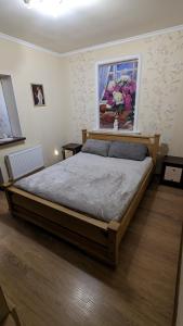 1 dormitorio con 1 cama grande y una pintura en la pared en TownHouse Euro жд вокзал, фонтан, чеки ПРРО, en Vínnytsia