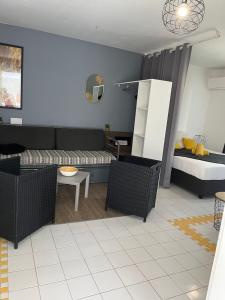 ein Wohnzimmer mit einem Sofa und einem Bett in der Unterkunft Studio Estelle Manganao in Saint-François