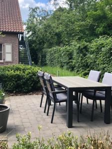 Une table et des chaises en bois sont disponibles sur la terrasse. dans l'établissement De Kempische Akker, à Westerlo