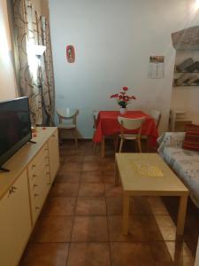 sala de estar con sofá y mesa con TV en Mini appartamento, en Livorno