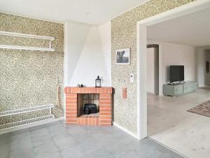 ein Wohnzimmer mit einem gemauerten Kamin und einem TV in der Unterkunft Holiday home LJUNGBY III in Ljungby