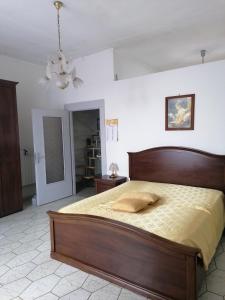 a bedroom with a large wooden bed in a room at Casa del Palazzo del Marchese in Tarquinia