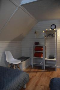een kamer met een bed en een stoel op zolder bij Lazdkalni in Ķimale