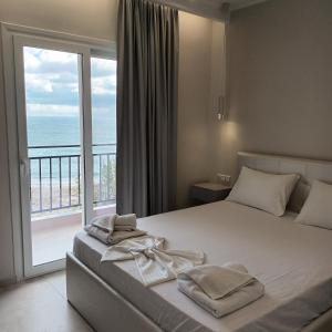 Schlafzimmer mit einem Bett und Meerblick in der Unterkunft Golfo Beach in Parga