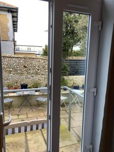 an open door to a patio with a table and chairs at Wicks at 26 in Sandown