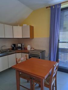 a kitchen with a wooden table and a table and chairs at Kairos B&B in San Giuseppe Jato