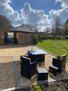 a patio with a table and chairs and a building at Valesmoor Farm in New Milton