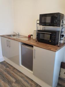 a kitchen with a counter with a microwave and a sink at 140 Bond in Blackpool