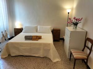 - une chambre avec un lit blanc, une chaise et une commode dans l'établissement La casa di Fabi, à Arcola