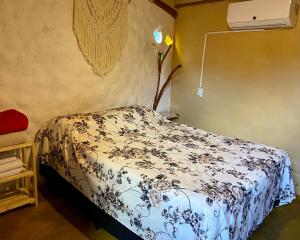 a bedroom with a bed with a blue and white blanket at Namastê Suítes e Chalés in Sao Jorge