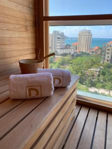 a window with towels on a wooden counter with a view at Dolls Hotel By Eurostars in Jounieh