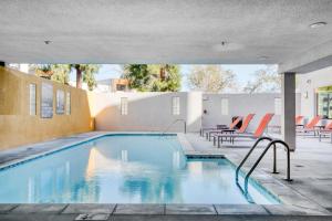 ロサンゼルスにあるStudio City 1BR w Gym Pool WD nr TJ WF LAX-628の建物の隣にスイミングプール(椅子、テーブル付)