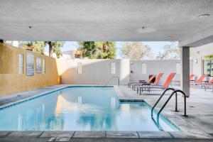 a swimming pool with chairs and a table next to a building at Studio City 1BR w Gym Pool WD nr TJ WF LAX-628 in Los Angeles
