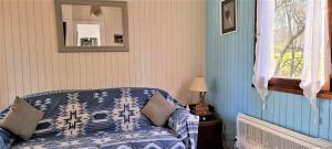 a blue couch in a room with a mirror at Weir Cottage in Balledent