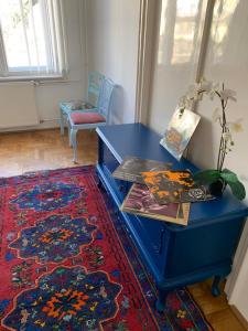 un escritorio azul con libros y una planta sobre una alfombra en Cargo Rooms and Apartment, en Budapest