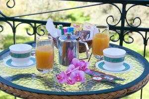 a glass table with a tray with drinks and flowers at Pension Gerania in Asos