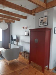 een woonkamer met een rode kast en een stoel bij Berni's home Apartament z tarasem in Sopot