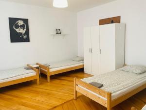 Pokoje Slawin في لوبلين: غرفة بها ثلاثة أسرة وخزانة