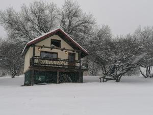 ein kleines Haus mit einem Dach im Schnee in der Unterkunft Casa rustica in Braşov