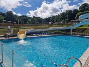 a large swimming pool with a water slide at Retreat to Oak Tree Lodge - A Romantic Getaway in Devon's Finlake Resort & Spa in Chudleigh