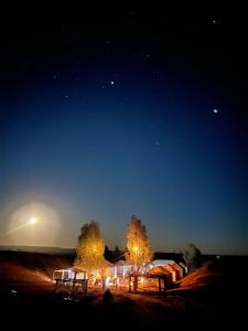a group of lights in a field at night at Merzouga Paradise Luxury Camp in Merzouga