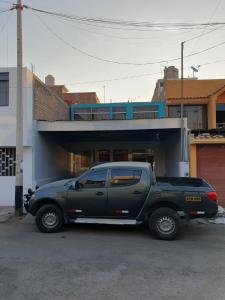a green truck parked in front of a building at Casa La Ruta Pisco in Pisco