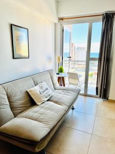 a living room with a couch and a large window at El Cairo 10 in Puerto Madryn