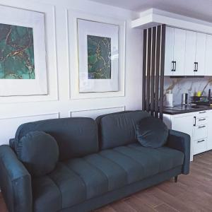 sala de estar con sofá azul y cocina en BaltikApart, en Hel