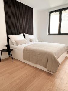 een witte slaapkamer met een groot bed en een raam bij SOL Baška Voda in Baška Voda