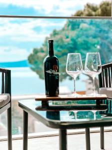 a bottle of wine sitting on a table with two glasses at SOL Baška Voda in Baška Voda