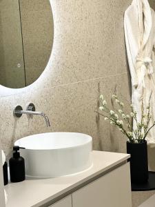 een badkamer met een witte wastafel en een spiegel bij SOL Baška Voda in Baška Voda