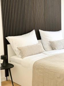 a bed with white pillows and a black headboard at SOL Baška Voda in Baška Voda
