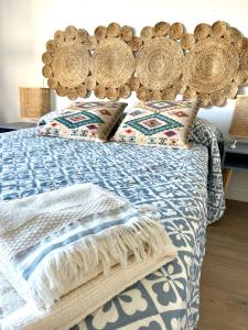 a bed with a blue and white comforter and pillows at Apartamento a estrenar en Ribamontán al Mar in Hoznayo