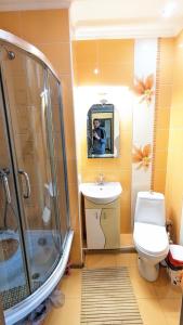 a man taking a picture of a bathroom with a toilet and shower at TownHouse Euro жд вокзал, фонтан, чеки ПРРО in Vinnytsya