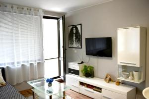 uma sala de estar com uma televisão e uma mesa de vidro em Морски Бриз em Varna City