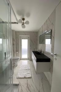 ein Bad mit einem Waschbecken und einer Glasdusche in der Unterkunft Appartamento al Mare in Montepaone Lido