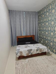 een slaapkamer met een bed in een kamer met behang bij Pretty Room in Shared Apartment in Ajman 