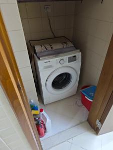 een wasmachine en droger in een kleine kamer bij Pretty Room in Shared Apartment in Ajman 