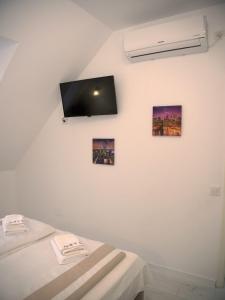 シビウにあるPensiunea Todorのベッド2台、壁掛けテレビが備わる客室です。