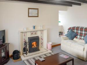 a living room with a fireplace and a couch at Breacwell Cottage in Bonar Bridge