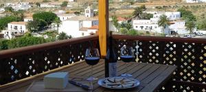 a table with two glasses of wine on a balcony at Casa Isabel 2 in Betancuría