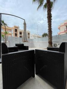 a patio with an umbrella and a palm tree at Cielo Stellato in Polignano a Mare