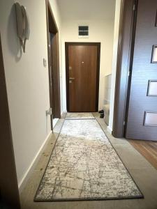 - un couloir avec une porte et un tapis au sol dans l'établissement Apartman Nikol, à Kumanovo