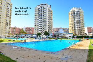 a swimming pool in a city with tall buildings at Armação de Pêra Praia Mar Sol in Armação de Pêra