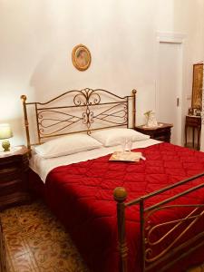 um quarto com uma cama grande e um edredão vermelho em LA CONCHIGLIA em Marsala