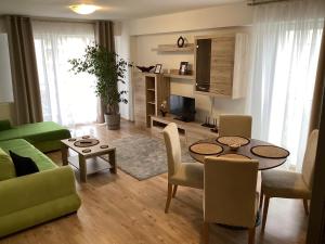 uma sala de estar com uma mesa e um sofá em Relaxing Bucharest Airport Residences & Therme-SELF CHECK-IN em Otopeni