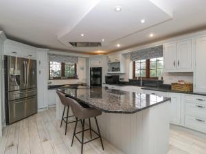 a kitchen with white cabinets and a large island at Sundowner Cottage in Axminster